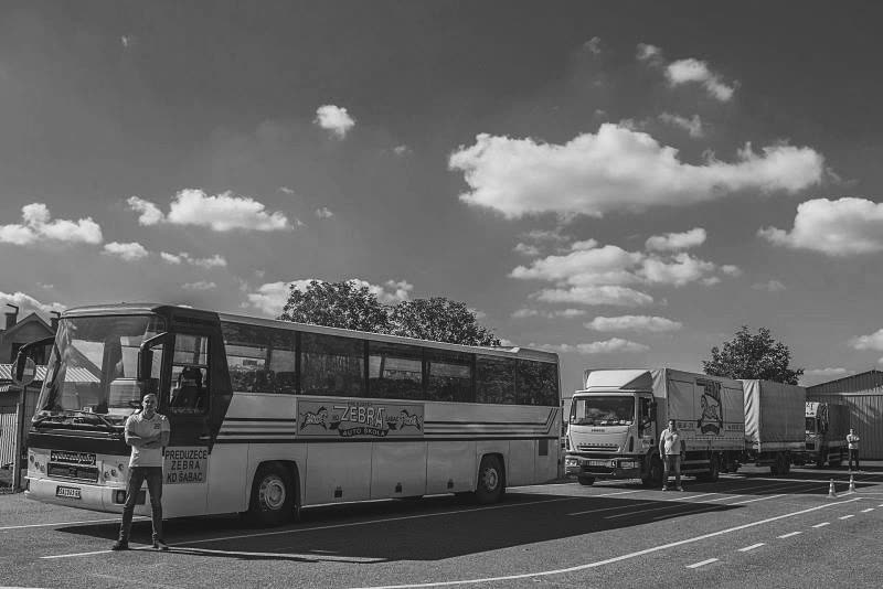 Autobus i kamion sa prikolicom na poligonu, pored njih instruktori
